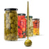 Jars of pickled vegetables with a ladle holding an olive on a white background